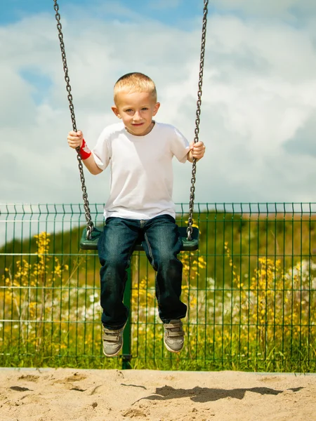 Kleine blonde Junge Kind Spaß auf einer Schaukel im Freien — Stockfoto