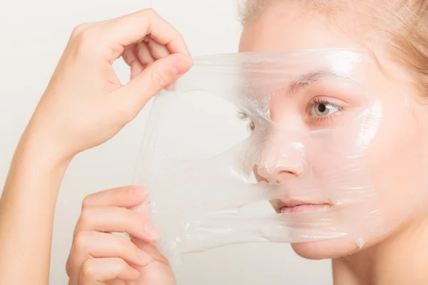 Flickan att ta bort peel off mask — Stockfoto