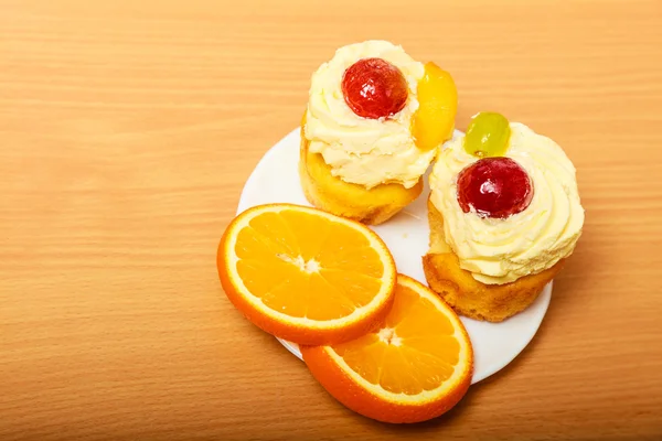 Горіхове вершкове печиво та апельсин на тарілці — стокове фото