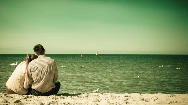 Couple sitting on beach — Stock Photo, Image