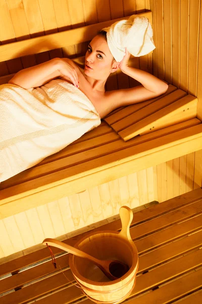 Femme couchée dans un sauna en bois — Photo