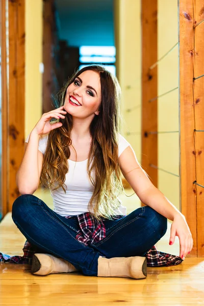 Girl in denim trousers sitting on floor — Stock Photo, Image