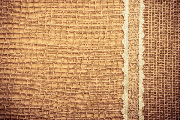 Marco de encaje sobre fondo de tela de arpillera — Foto de Stock