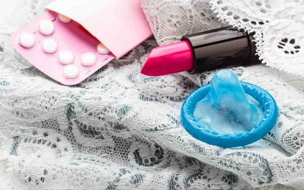 Pills, condom and lipstick — Stock Photo, Image