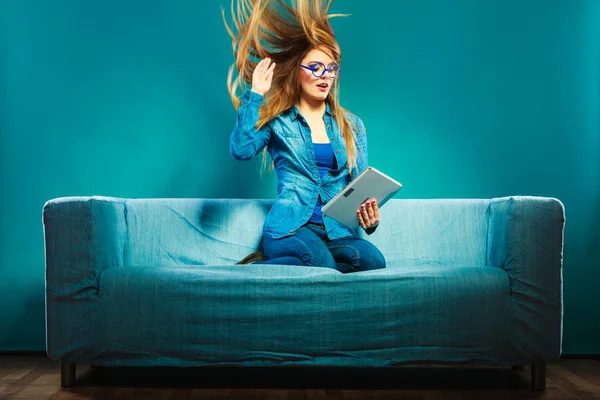 Menina cabelo soprando com tablet no sofá — Fotografia de Stock