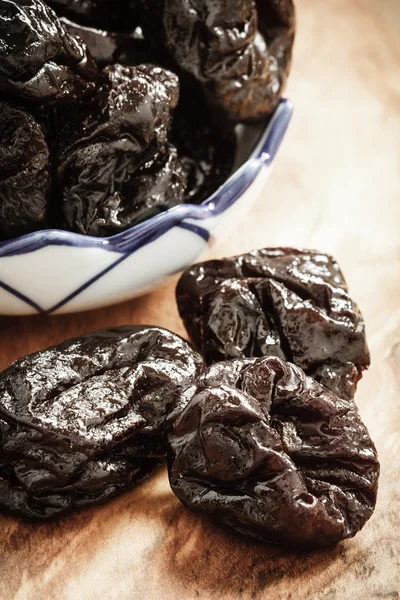 Dried plums prunes on wooden table — Stock Photo, Image