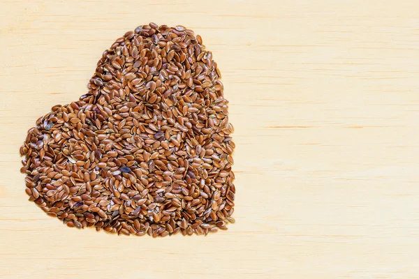 Raw flax seeds heart shaped — Stock Photo, Image