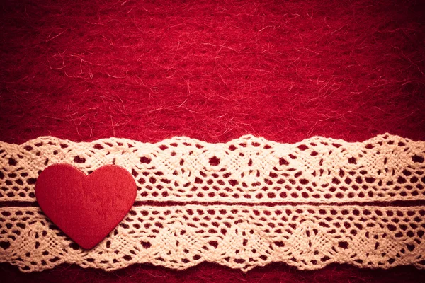 Corazón sobre fondo de tela roja — Foto de Stock