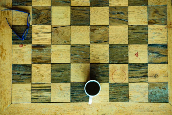 Tavolo a scacchi con bicchieri e tazza di caffè — Foto Stock