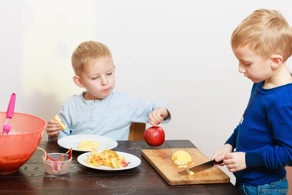 Blond boys children kids with kitchen knife cutting fruit apple — Stock Photo, Image