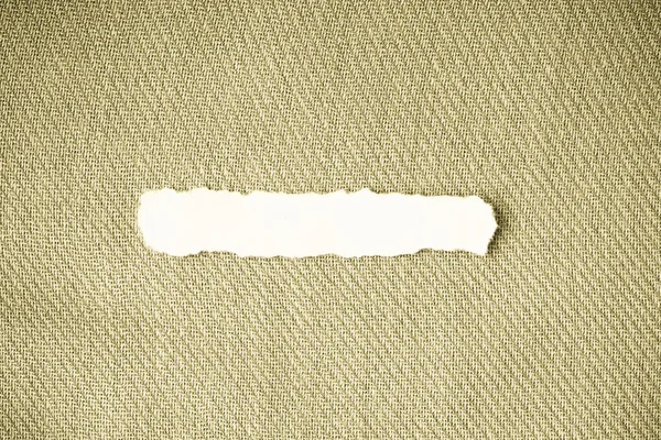 Trozo de papel de desecho sobre materia textil —  Fotos de Stock