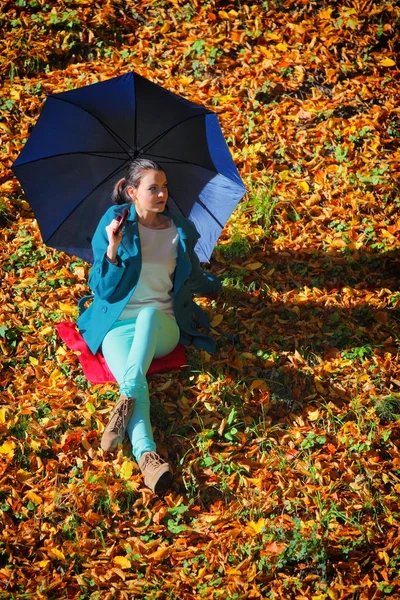 Relaxační s deštníkem v podzimní park mladá dívka — Stock fotografie