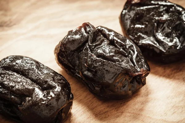 Dried plums on wooden table — Stock Photo, Image