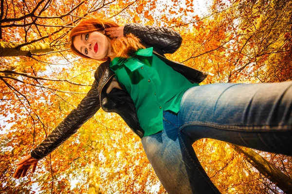 Unusual angle of young woman in autumn park — Stock Photo, Image