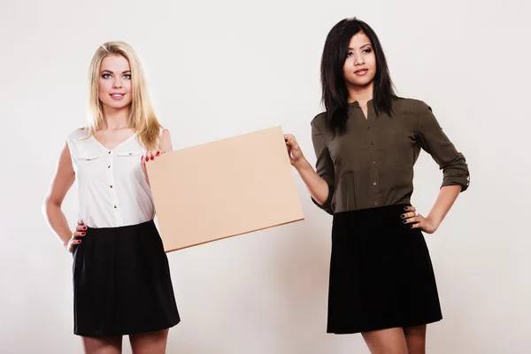 Two women with blank board — Stock Photo, Image