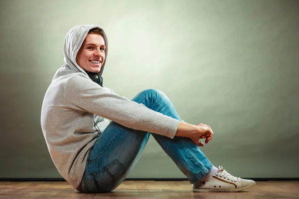 Hooded man sitting on floor — Stock Photo, Image