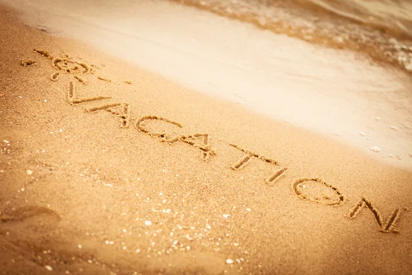 A Palavra Férias Escrito na Areia em uma Praia — Fotografia de Stock