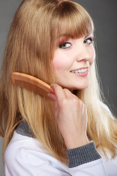 Woman combing her hair — Stock Photo, Image