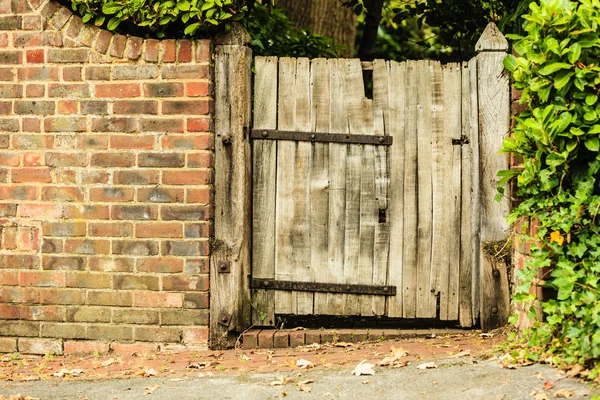 Puerta de madera vieja rústica en pared de ladrillo — Foto de Stock