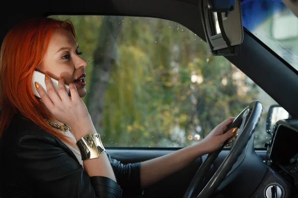 Chica hablando en el teléfono móvil mientras conduce el coche . — Foto de Stock