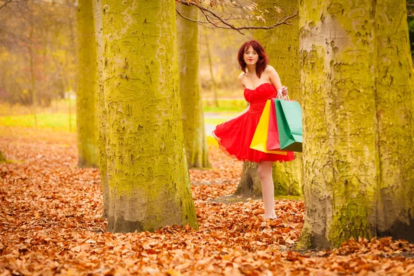 Herfst shopper vrouw met verkoop tassen buiten in park — Stockfoto