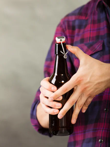 Homem segurando uma garrafa de cerveja — Fotografia de Stock