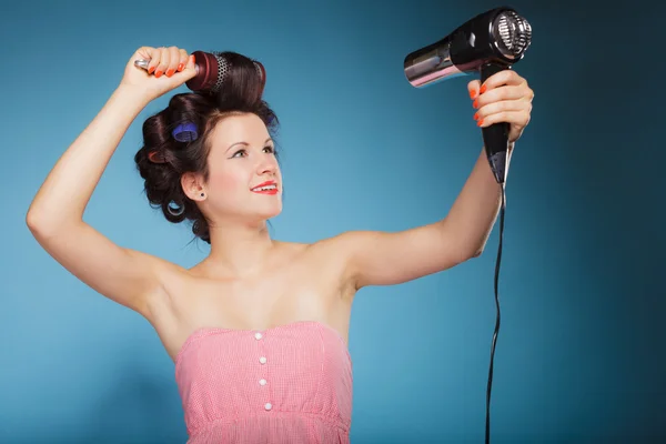 Girl with curlers in hair holds hairdreyer — Stock Photo, Image