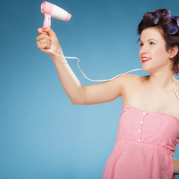 Ragazza con bigodini in capelli tiene asciugacapelli — Foto Stock