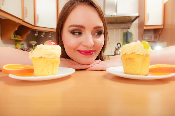 Mulher olhando para deliciosos bolos . — Fotografia de Stock