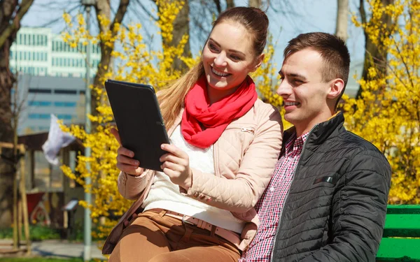 Couple avec tablette assis sur banc extérieur — Photo