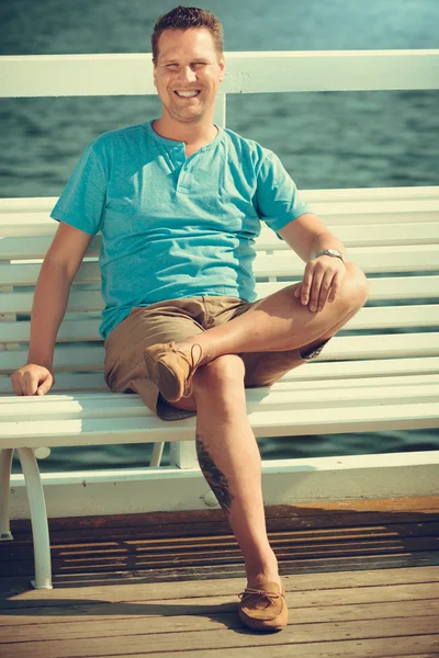 Handsome  tourist sitting on pier. — Stock Photo, Image