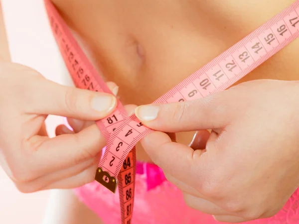 Woman measuring her waistline — Stock Photo, Image