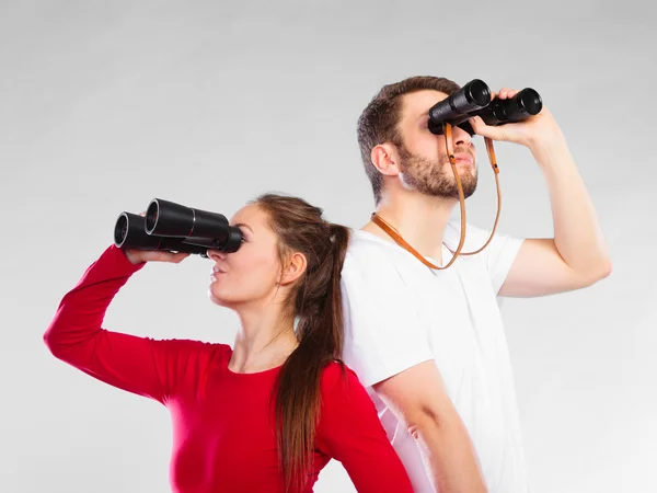 Sporty couple holding binoculars — Stock Photo, Image