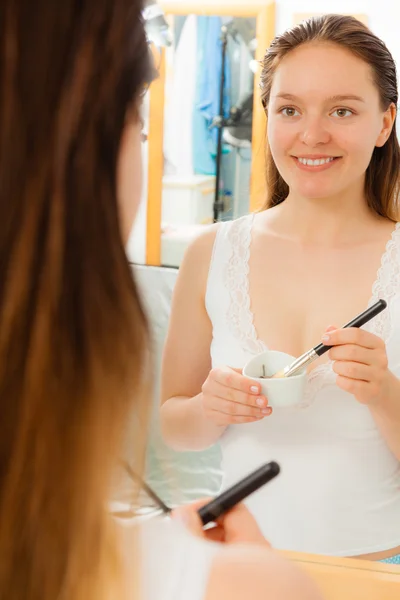 Woman applying mud facial mask — Stock Photo, Image