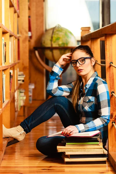 Girl in library pointing to globe — Stock Photo, Image