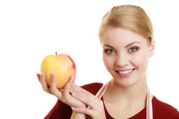 Housewife in kitchen apron offering apple healthy fruit Stock Picture