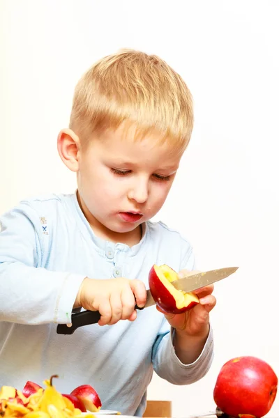 Kind schneidet Apfel mit Küchenmesser, kocht. — Stockfoto