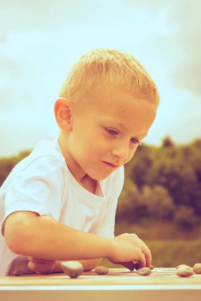 Little boy clever child playing checkers in park — Stock Photo, Image