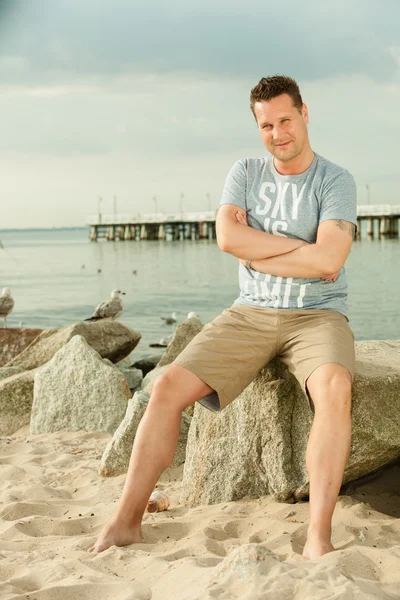 Fashion portret van knappe man op het strand — Stockfoto