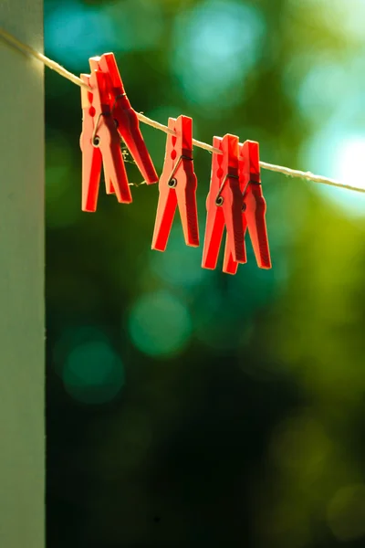 Red clothes pegs on string outdoor. — Stock Photo, Image
