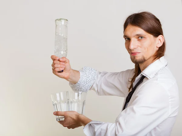 Young man bartender pouring a drink, studio shot — Stock Photo, Image