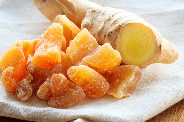 Closeup root and candied ginger on rustic table — Stock Photo, Image