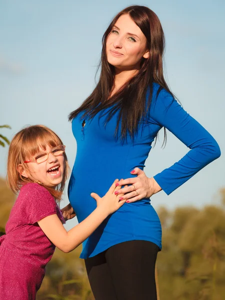 Femeie însărcinată cu fiica ei în parc în aer liber — Fotografie, imagine de stoc