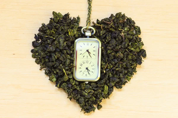 Green tea leaves heart shaped and watch — Stock Photo, Image