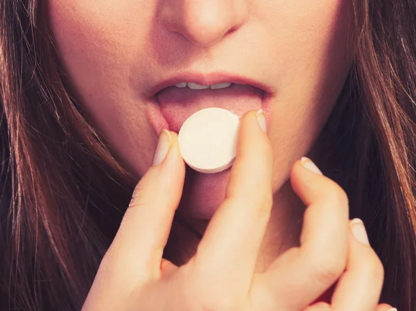 Woman taking painkiller pill tablet — Stock Photo, Image