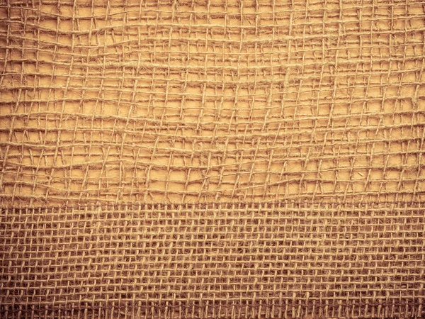 Jute ribbon on burlap cloth background — Stock Photo, Image