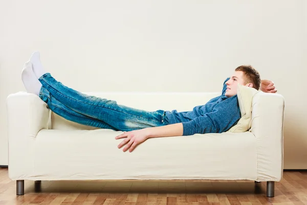 Junger Mann entspannt sich auf Couch — Stockfoto