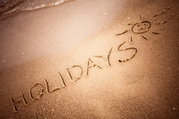 Word holidays written in the sand — Stock Photo, Image