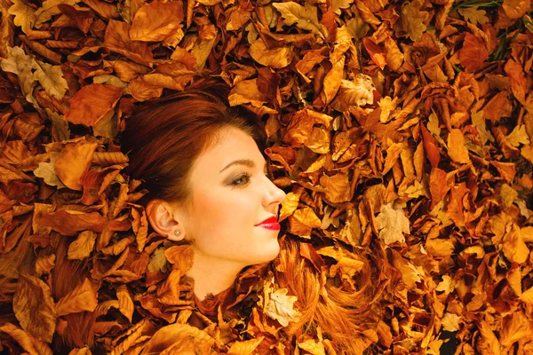 Mujer cubierta con hojas naranjas de otoño . —  Fotos de Stock