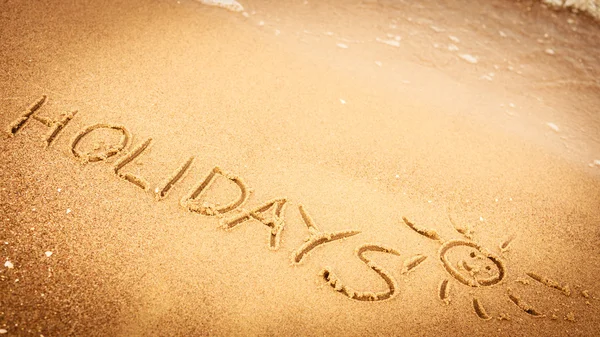 La parola vacanze scritte nella sabbia — Foto Stock